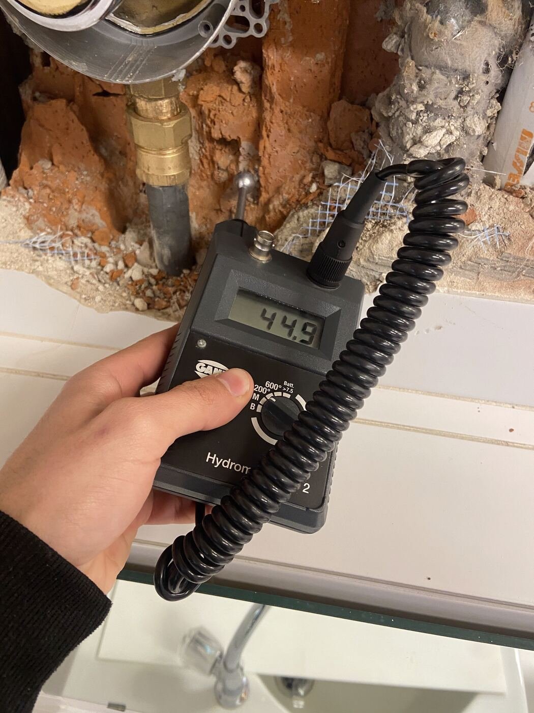 Feuchtemessung an einer geöffneten Wand während der Bautrocknung