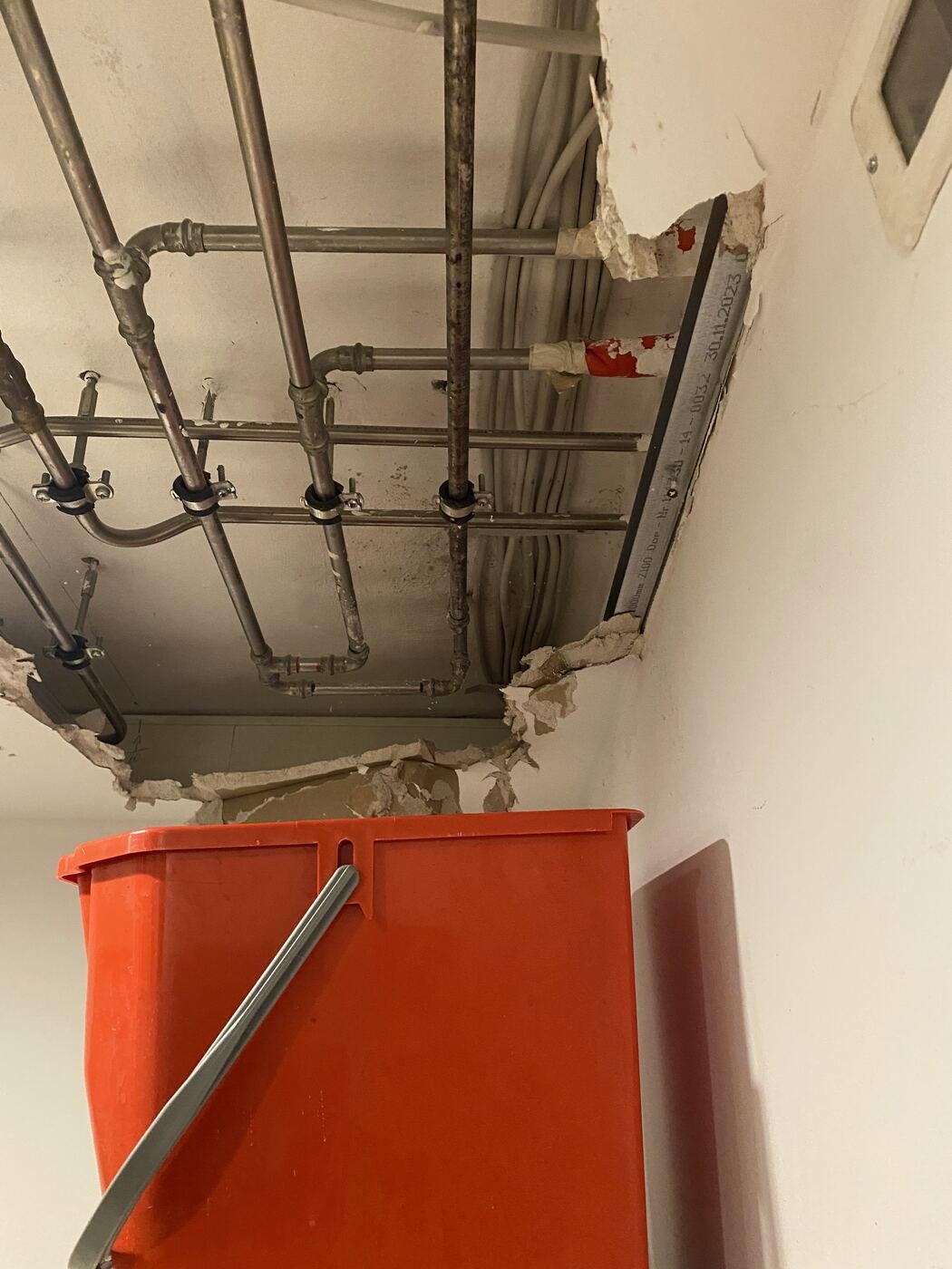 Geöffnete Decke mit Leitungen nach einem Wasserschaden in der Wohnung